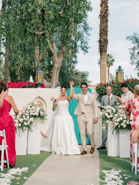 Artisan Event Floral Decor ceremony aisle with white pedestal arrangements and a turquoise door