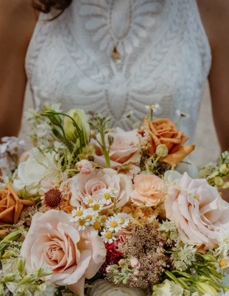 Flower Towne bride in a lace dress holding a blush rose bouquet