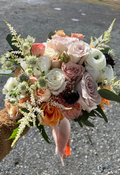 Flower Towne bridal bouquet of blush and mauve roses tied with ribbon