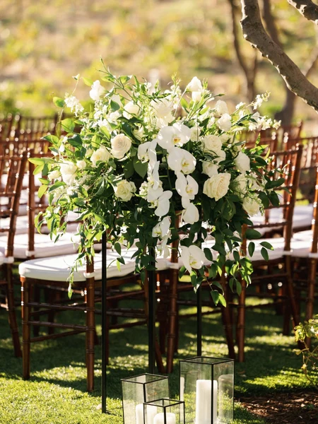 Haley Simon Events white floral arrangements lining a ceremony aisle on a lawn