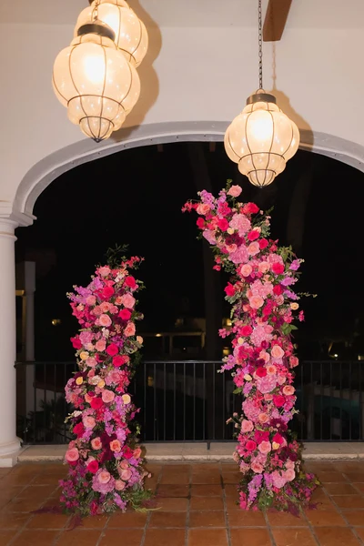 Haley Simon Events pink floral pillars under lanterns at an evening celebration