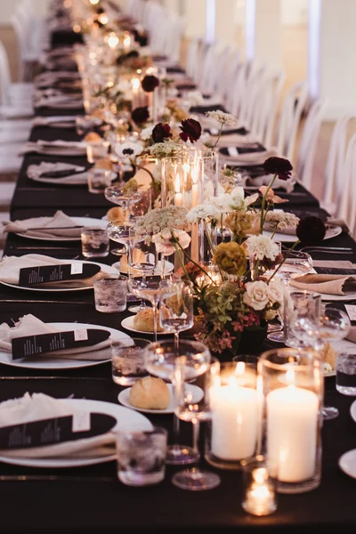 Events Inspired long reception table with black linens, candles and garden florals