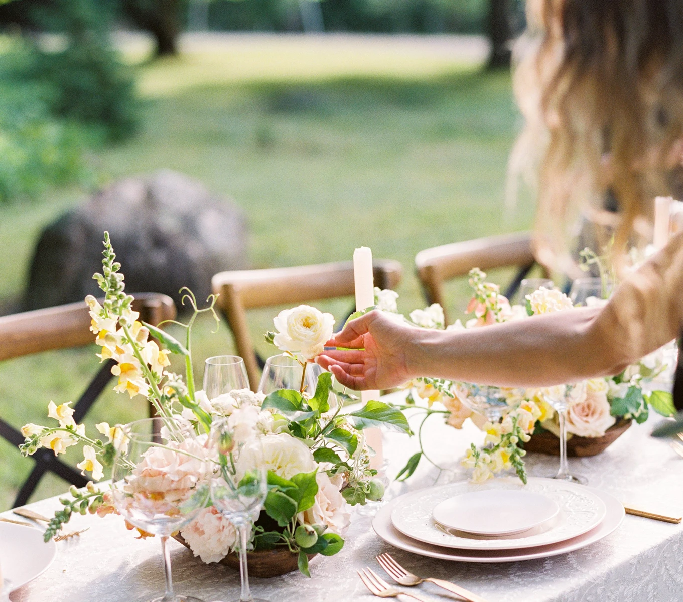 BLOOM floral design low centerpiece of garden roses and snapdragons on an outdoor table in the woods