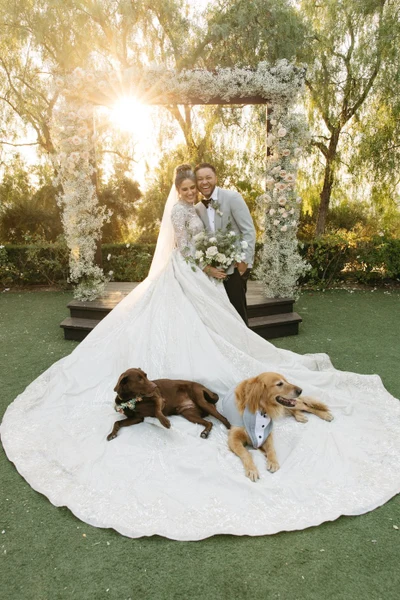 Khoa Photography bride and groom with two dogs beneath a floral arch at a winery wedding