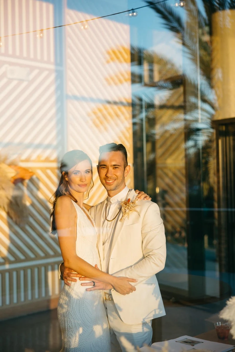Khoa Photography wedding couple photographed through glass in warm evening light