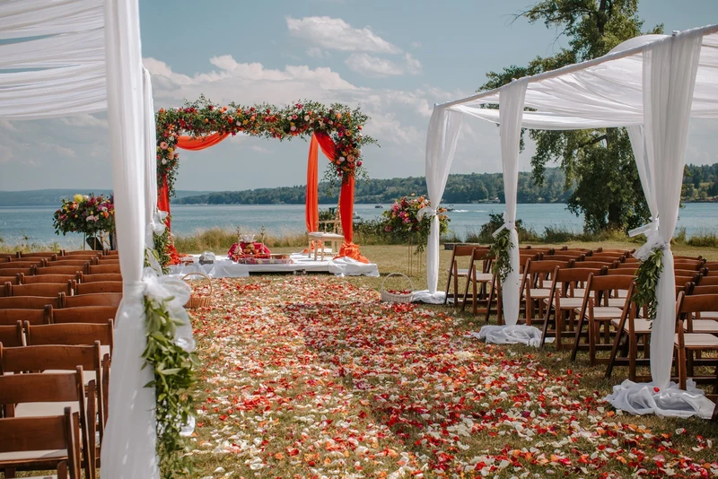 Folls' Flowers floral arch and petal lined aisle at a lakeside ceremony