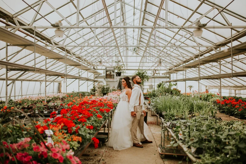 Addie Fath Photography newlyweds standing among flowers inside a greenhouse