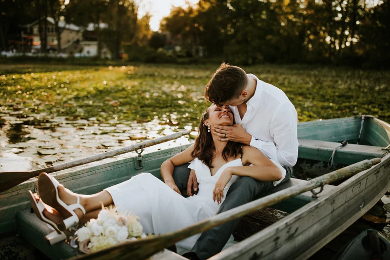 Addie Fath Photography couple embracing in a rowboat on a lily pond at golden hour