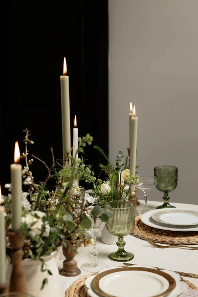 She Rents Vintage candlelit table setting with green glassware and woven chargers