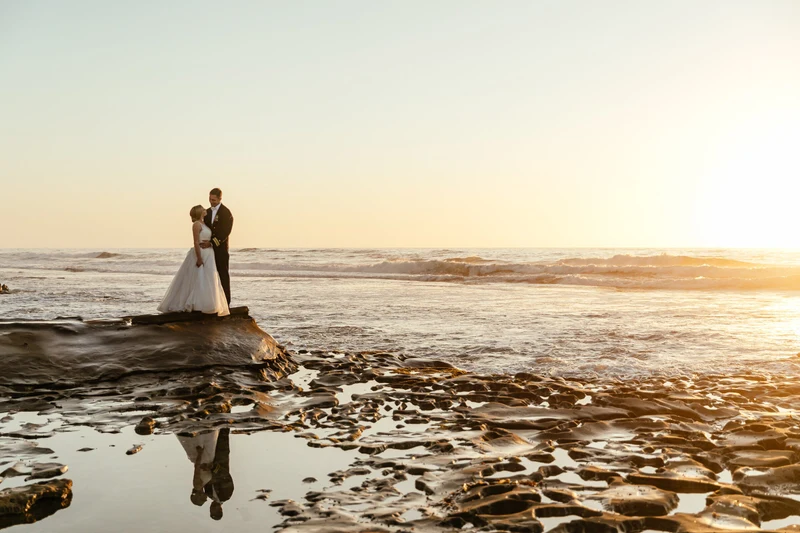 LEAF Wedding Photography bride and groom embracing on coastal rocks at sunset