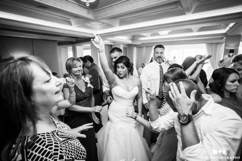 Sound Prodigy bride dancing with guests at an indoor wedding reception