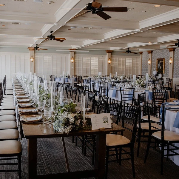 Crown Coordination reception room set with long farm tables, greenery and candles