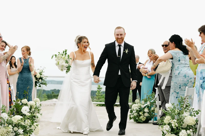 Moondance Flower Farm newlyweds walking down the aisle surrounded by lush white and green seasonal wedding flowers