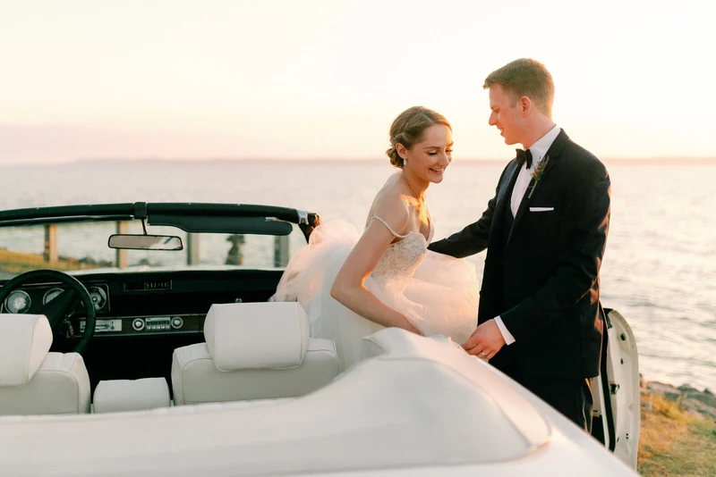Anna Beth Smith couple beside a vintage convertible on the Lake Michigan shore at sunset