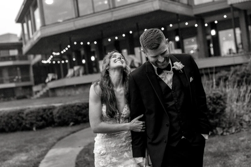 Anna Beth Smith black and white portrait of a laughing couple outside a venue hung with string lights