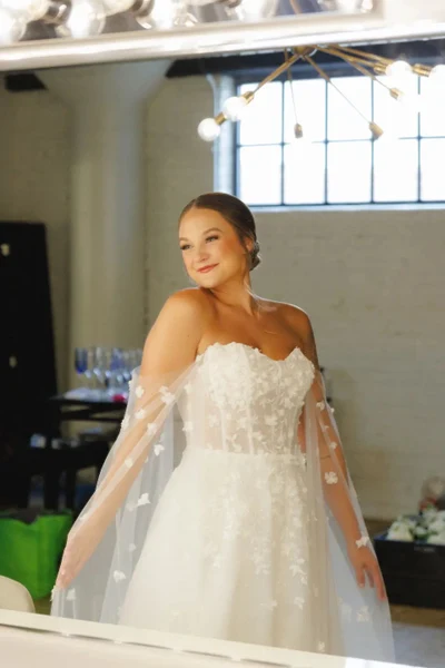 Beautiful Memories bride with natural glam makeup and a low updo in a getting-ready room
