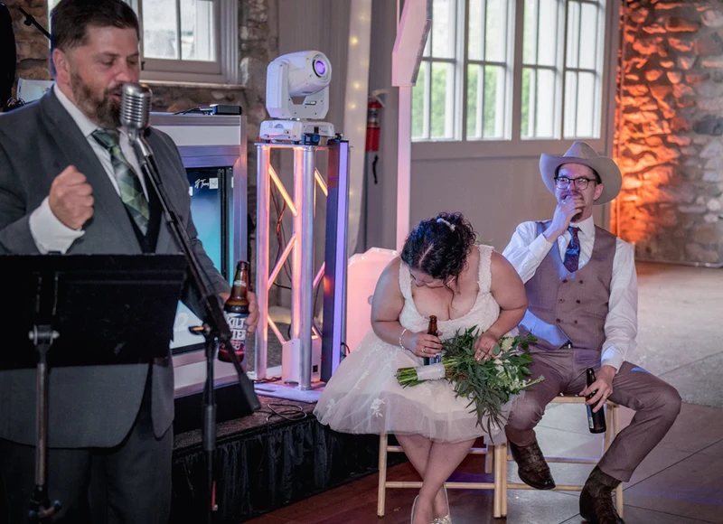 A+ Entertains emcee at the microphone as the couple laughs