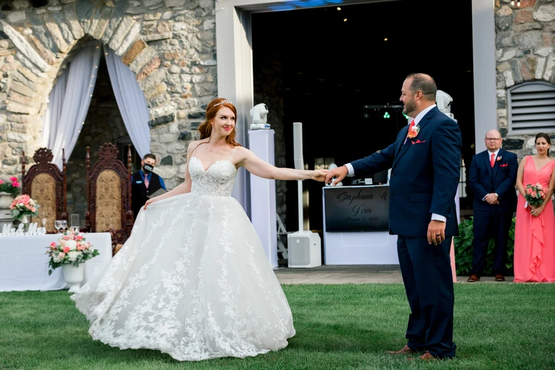 A+ Entertains first dance on the lawn in front of the DJ booth at a stone venue