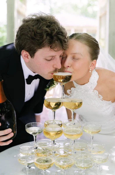 Little White Dress Events newlyweds sipping from a champagne tower outdoors