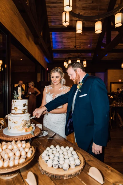 Brittany Juravich Photography bride and groom cut their rustic fall wedding cake during a Tailwater Lodge wedding reception