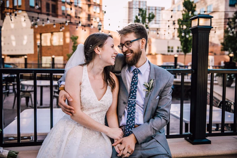 Brittany Juravich Photography newlyweds laughing together on a city patio under string lights at dusk