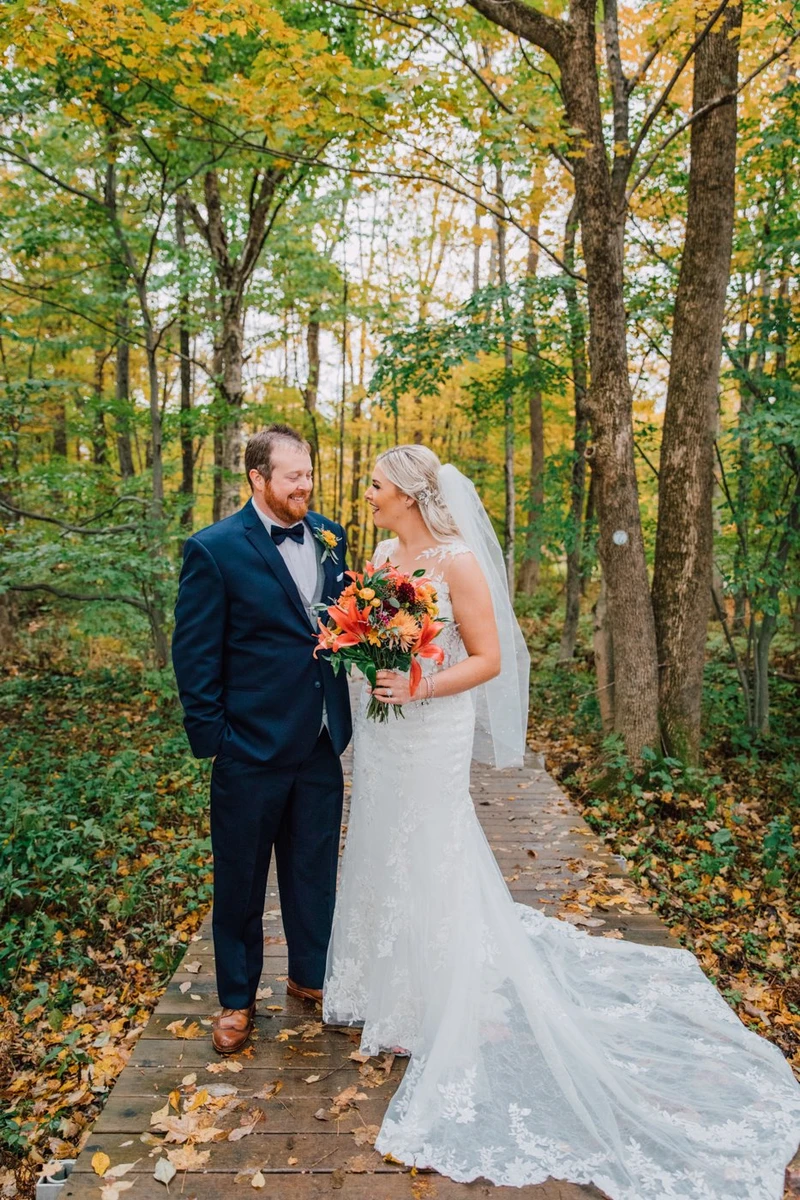 Brittany Juravich Photography bride and groom stand on a boardwalk during forest wedding photos in Altmar NY