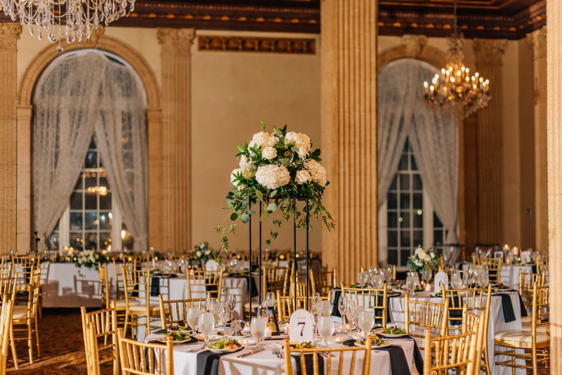 RD Events & Design ballroom reception tables with tall white floral centerpieces beneath chandeliers
