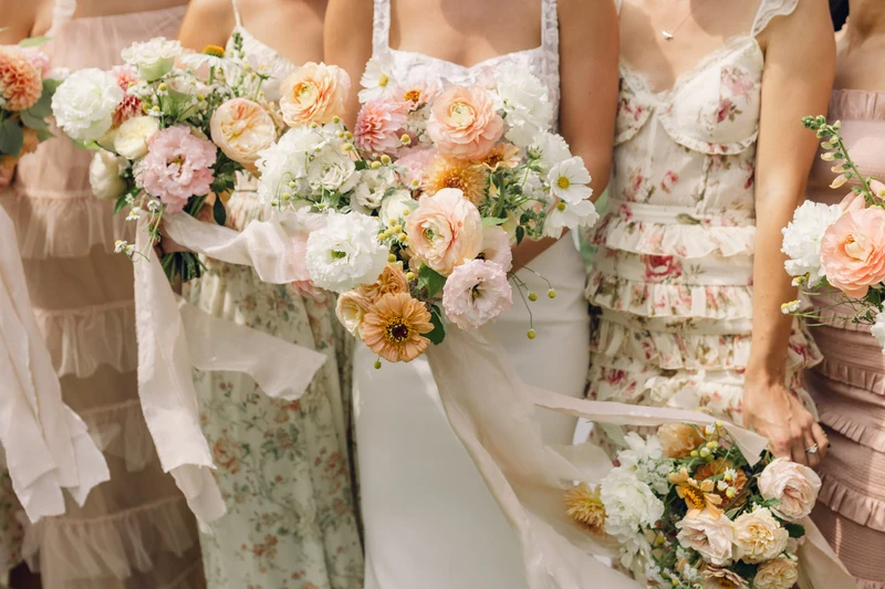RD Events & Design bridal party holding peach, pink and white bouquets