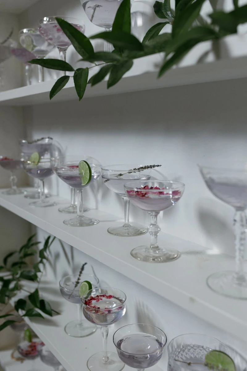 RD Events & Design garnished cocktails in coupe glasses displayed on white shelves