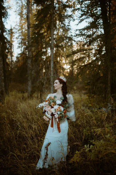 Joshua Veldstra Photography bride holding a bouquet in a spruce forest in warm evening light