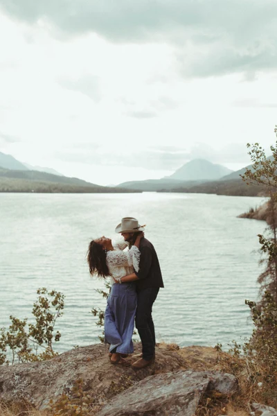 Joshua Veldstra Photography couple embracing on a rocky bluff above a mountain lake