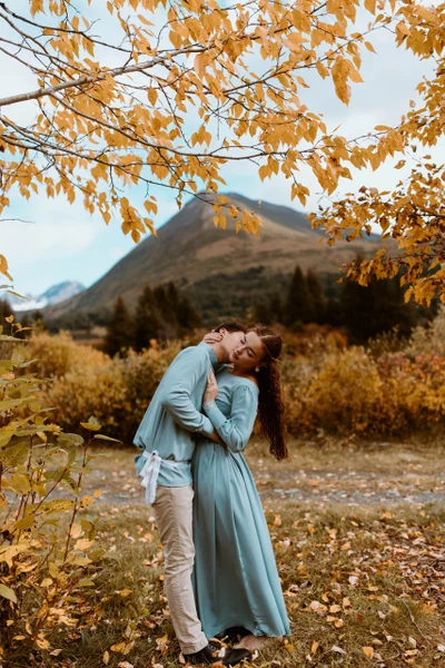 Joshua Veldstra Photography couple embracing under autumn leaves with mountains behind