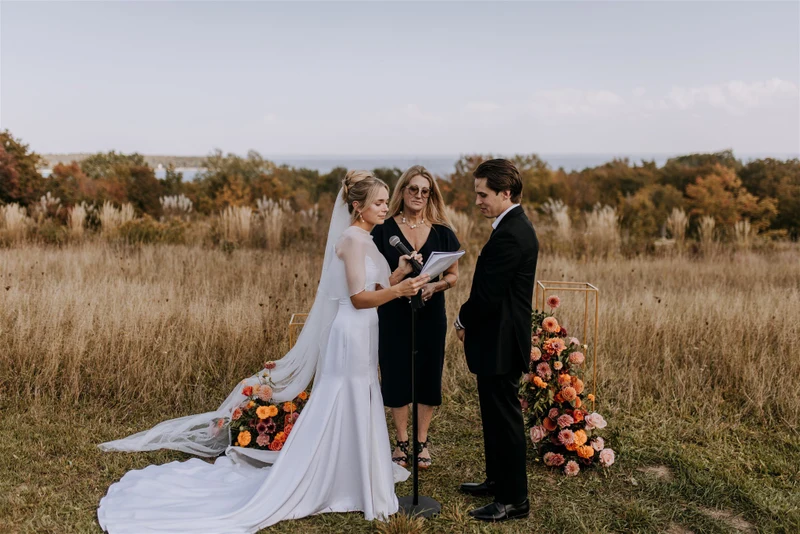 Bittersweet & Co. ceremony in an open field with a floral arch and ground arrangement