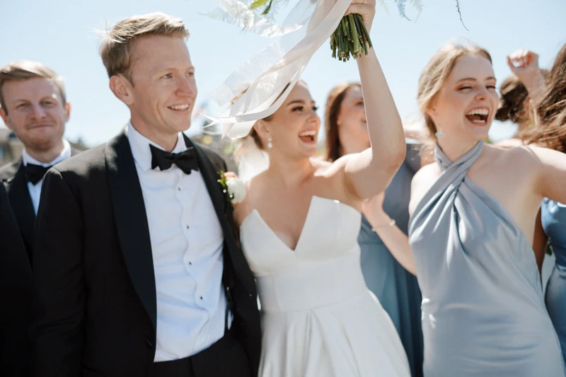 Michael Murphy IV Photography newlyweds raising a bouquet among the cheering wedding party