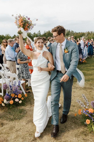 Michael Murphy IV Photography bride and groom cheering down an outdoor aisle lined with wildflowers