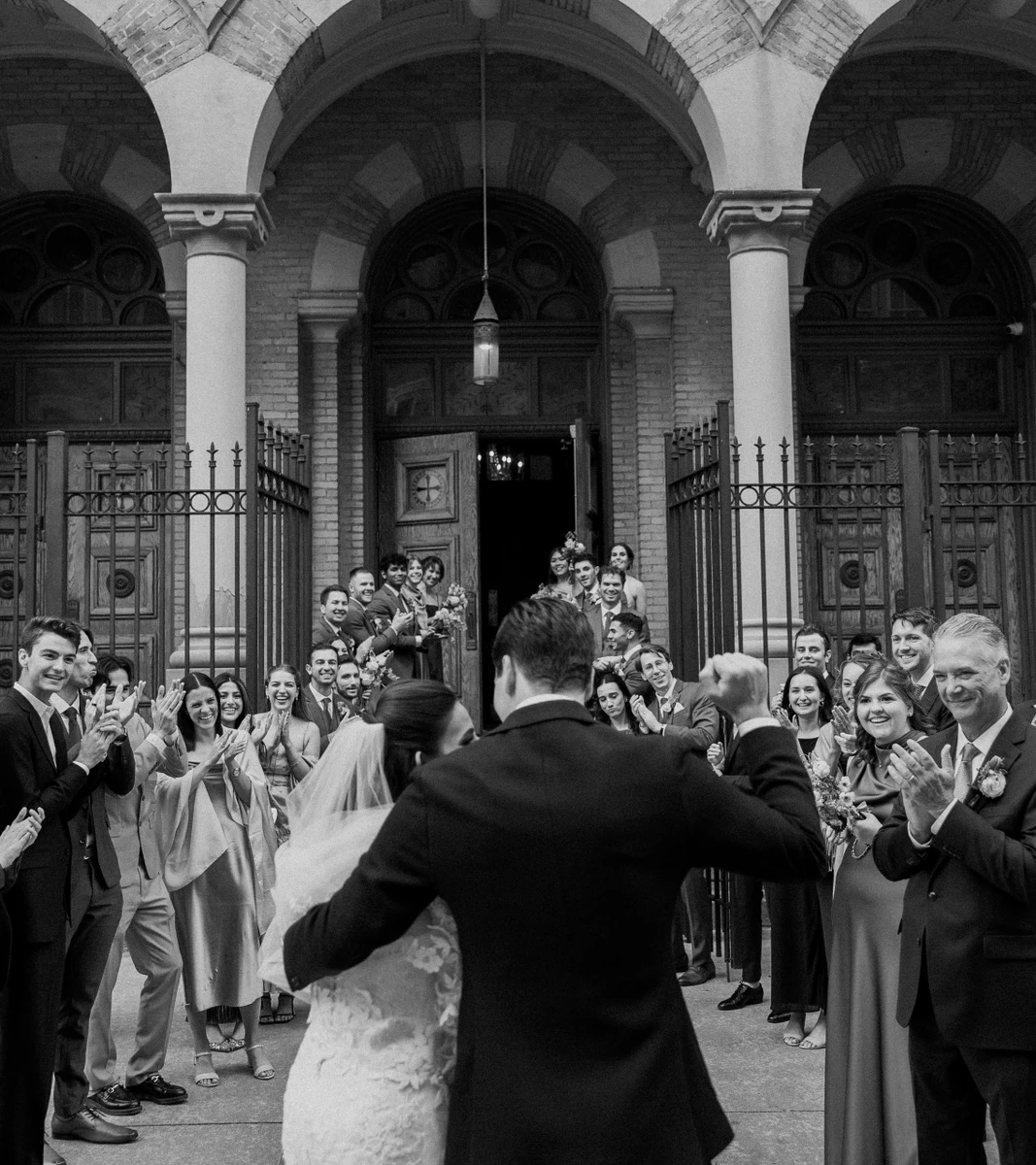 Michael Murphy IV Photography black and white photo of newlyweds greeted by cheering guests outside a church