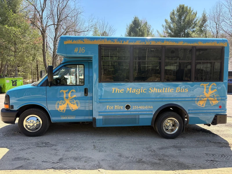The Magic Shuttle Bus blue bus with gold lettering, seen from the side