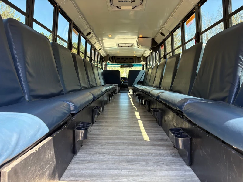 The Magic Shuttle Bus interior with long bench seating down both sides and cup holders