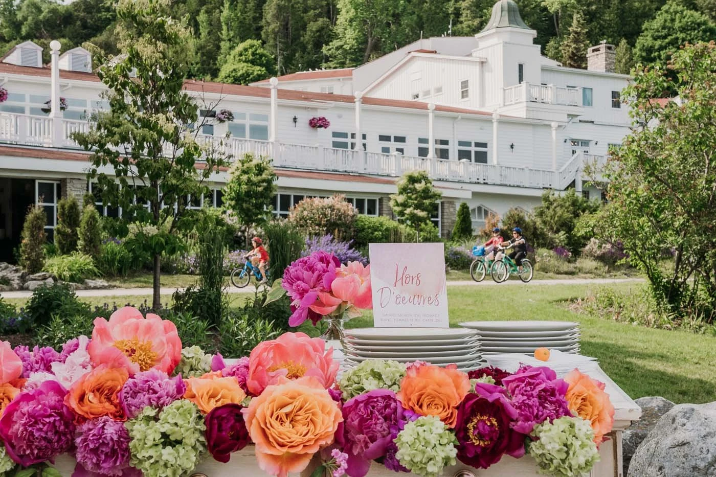 Amy Kate Designs garland of peonies and garden roses along an outdoor reception table on a resort lawn