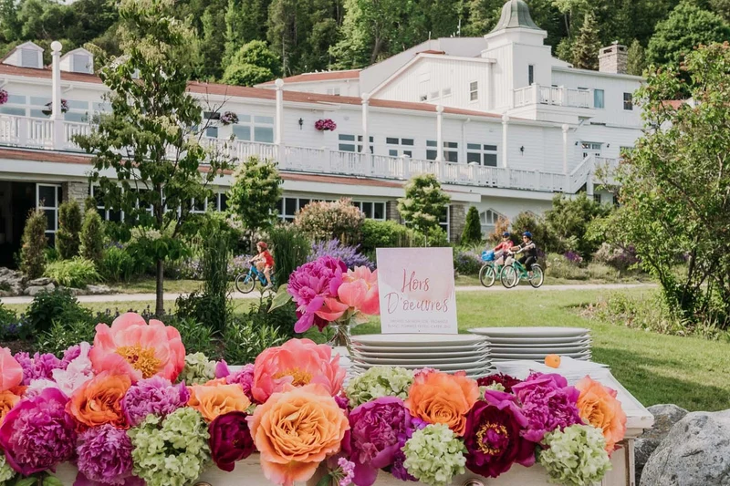 Amy Kate Designs garland of peonies and garden roses along an outdoor reception table on a resort lawn