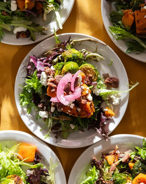 Madeline's Catering plated salads with roasted squash, Brussels sprouts and pickled onion
