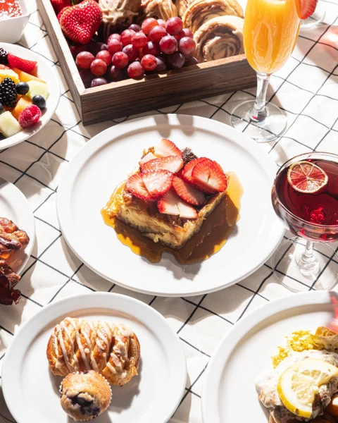 Madeline's Catering brunch spread with strawberry French toast, pastries and a mimosa