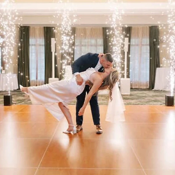 DJ Mike Melice cold sparks behind a couple in a dance floor dip