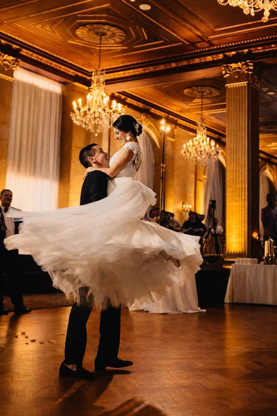 DJ Mike Melice first dance lift in a gilded ballroom with chandeliers