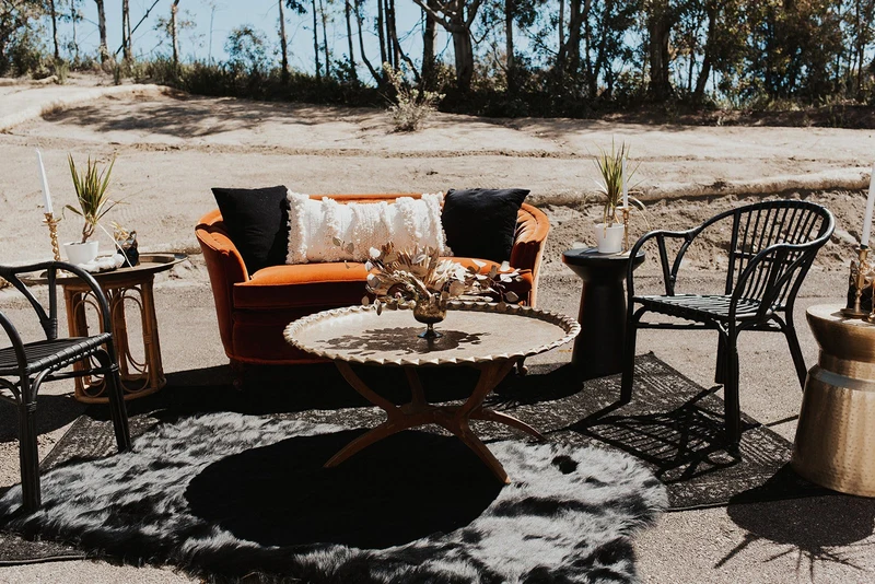 Wonder Event Rentals velvet sofa lounge set with rattan chairs and rugs at an outdoor event