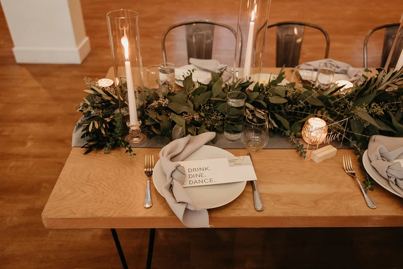 Wonder Event Rentals hairpin leg table set with greenery, candles and a dinner place setting