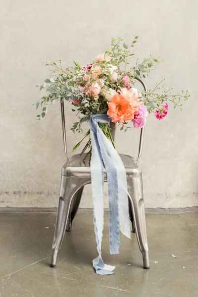Wonder Event Rentals metal bistro chair holding a bouquet