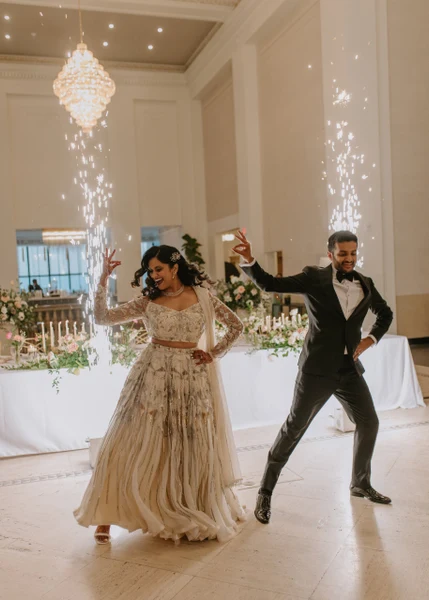 Eliza Jane Events couple dancing in a ballroom with a chandelier and cold spark fountains