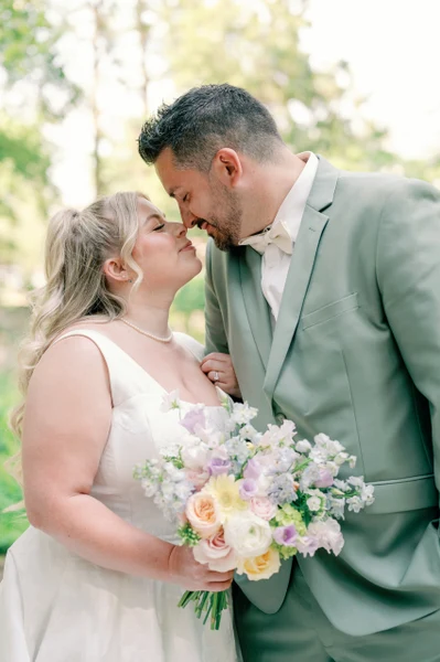 Eliza Jane Events couple with a pastel bouquet in a wooded garden