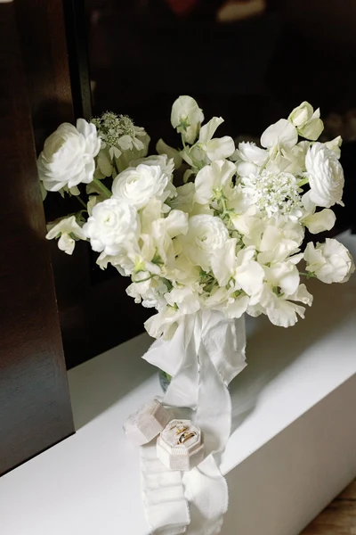 Eliza Jane Events white bridal bouquet tied with ribbon beside ring boxes